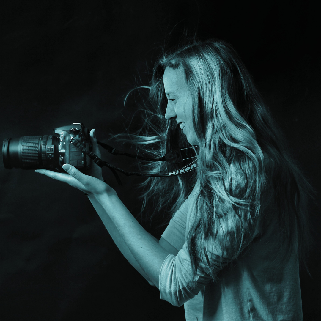 blue filtered profile of woman holding camera